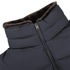 Close-up of a navy blue, zip-up goose down quilted gilet from Herno, featuring a high collar and lined on the inside with brown faux fur for added warmth.