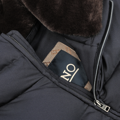 Close-up of a dark jacket with an inner pocket partially unzipped, revealing a fabric tag labeled "ONO". The interior appears to have a brown, fur-like lining. This Herno Navy Blue Nylon Goose Down Quilted Gilet is designed with water-repellent fabric and insulated with goose down for added warmth.