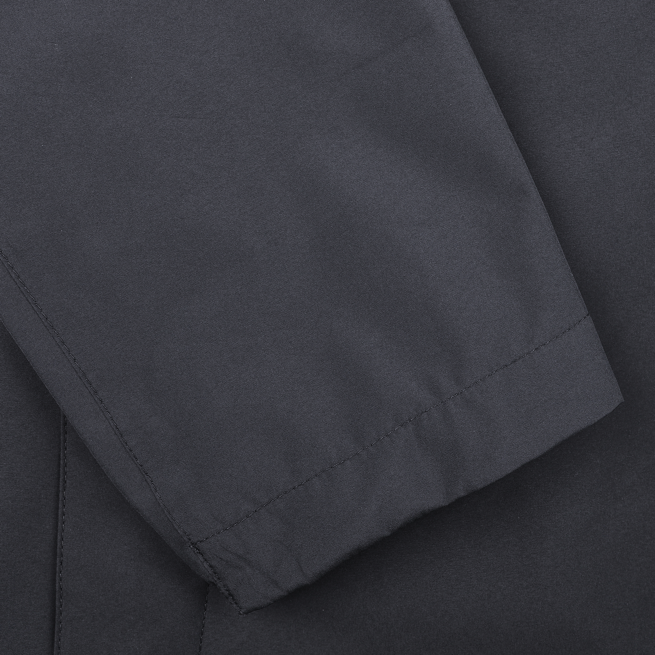 Close-up of a navy blue sleeve with clean stitching on smooth, waterproof nylon fabric, highlighting the refined craftsmanship of this lightweight Gore-Tex blouson by Herno.