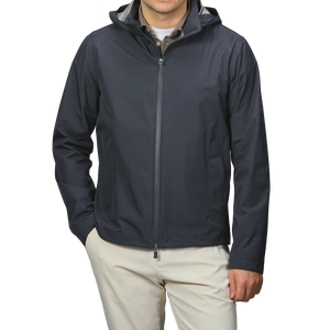 A person in a Herno Navy Blue Nylon Gore-Tex Blouson with light pants stands with one hand in their pocket.