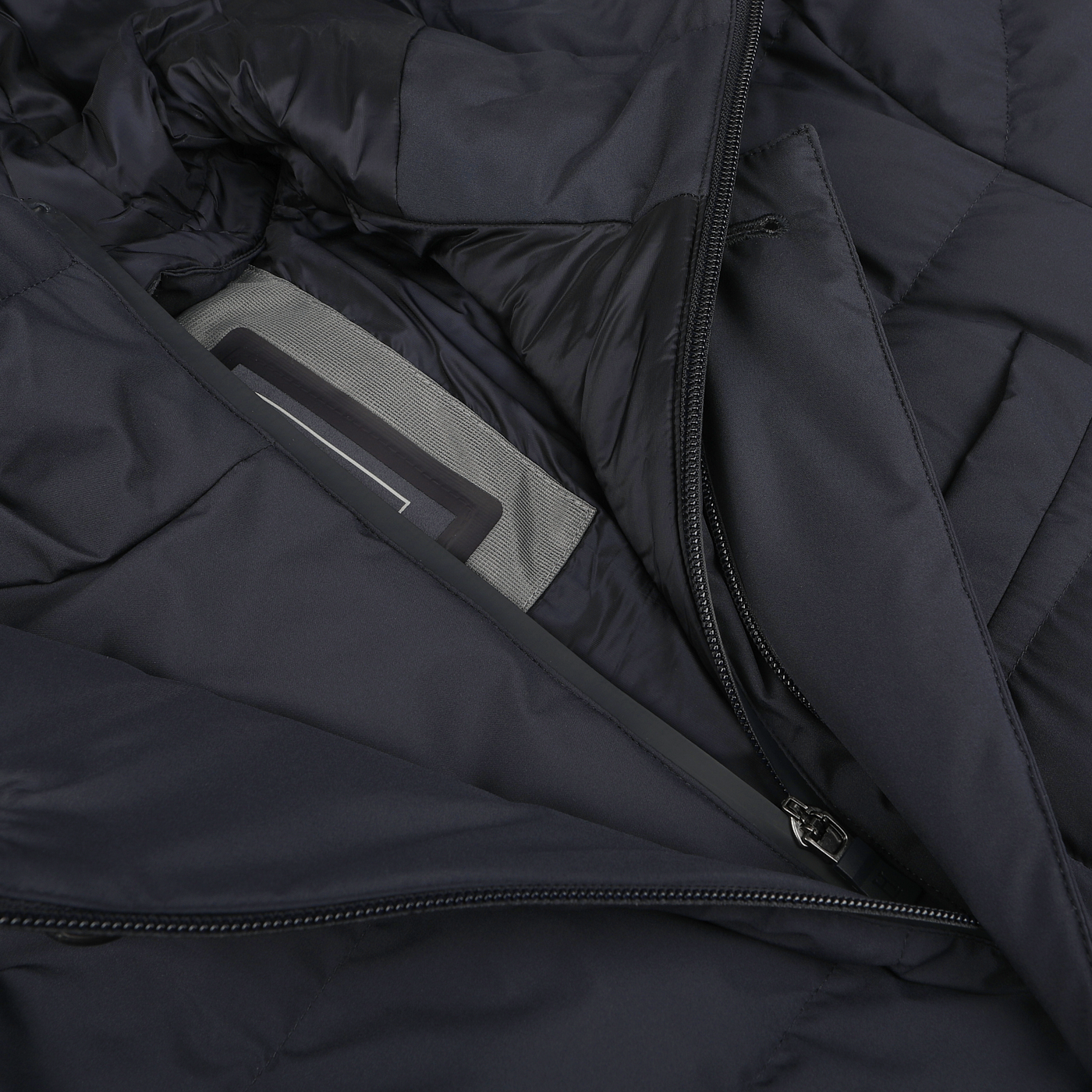 Close-up image of a Navy Blue Nylon Gore-Tex Laminar Coat's open zipper, revealing an interior grey pocket that appears to hold a rectangular object, showcasing the sleek design often found in high-end Herno garments.