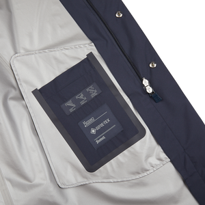 A Navy Blue Nylon Laminar Car Coat by Herno with a pocket and label on it.