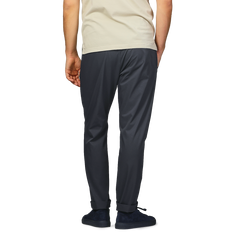 Back view of a person in a beige shirt and Herno's navy blue nylon stretch drawstring trousers, with hands in pockets.