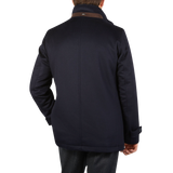 The back view of a man wearing a Herno Navy Blue Water Repellent Cashmere Car Coat in stormy weather.
