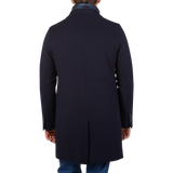 The back view of a man wearing a Herno navy wool down padded coat.