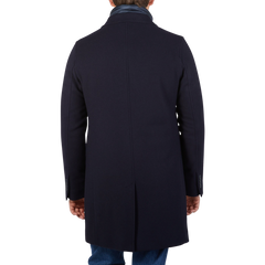 The back view of a man wearing a Herno navy wool down padded coat.