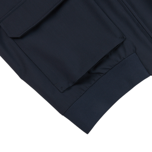 A close up of a wind-resistant navy blue Herno Navy Wool Loro Piana Storm System Blouson with pockets.