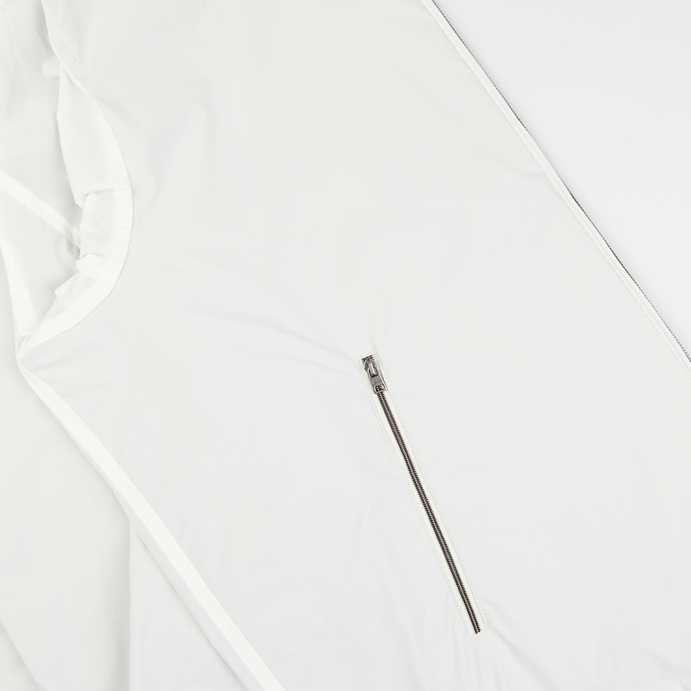 A metal zipper partially open on a water-resistant Herno Olive Green White Reversible Nylon Blouson fabric background.
