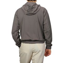 A person wears a Herno Taupe Beige Nylon Jersey Hood Jacket paired with light pants, facing away from the camera against a plain background.