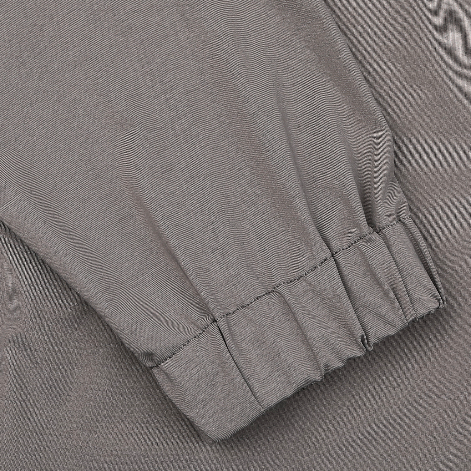 Close-up of a taupe beige nylon jersey sleeve with wrist elastic and visible stitching from the Herno technical hood jacket.