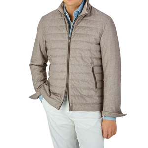 A man sporting a water-repellent Herno Taupe Beige Silk Cashmere Water-Repellent Jacket and slim fit white pants.