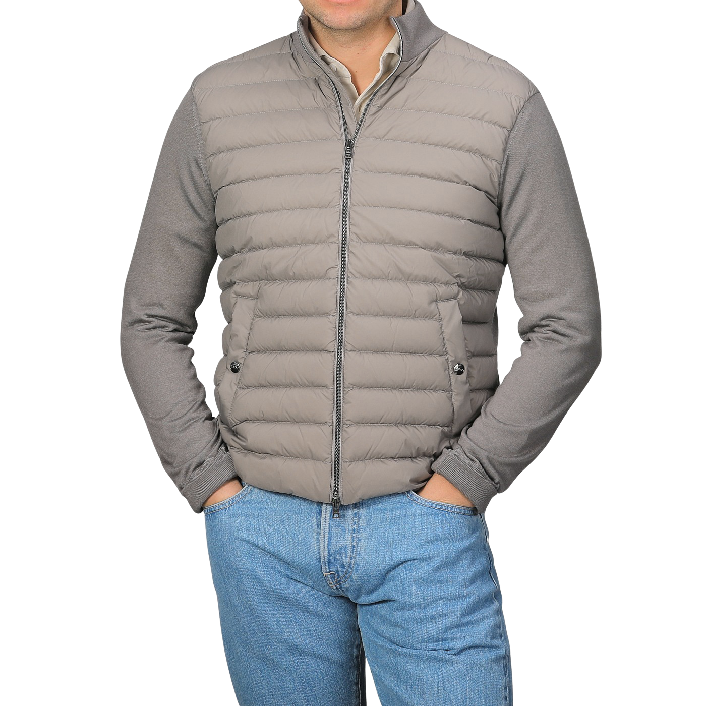 A person stands with hands in pockets, wearing a Herno Taupe Beige Wool Silk Nylon Padded Jacket over blue jeans against a neutral background.