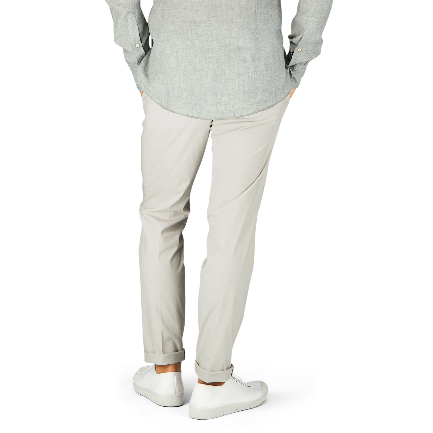Man in casual attire standing with hands in pockets, wearing Hiltl cream beige cotton nylon slim chinos.