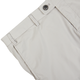 Close-up view of a Hiltl Cream Beige Cotton Nylon Slim Chinos waistband with button closure.