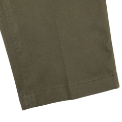 Close-up of the hem of Hiltl's Dark Green Cotton Stretch Regular Fit Chinos, highlighting the precise stitching against a light gray background.