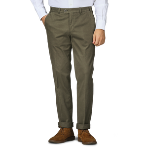 A person wearing Hiltl's Dark Green Cotton Stretch Regular Fit Chinos, a white shirt, and brown suede shoes.