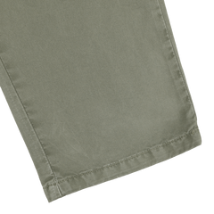 Close-up of a leg from the Green Washed Cotton Gabardine Slim Chinos by Hiltl, showcasing visible stitching near the hem.