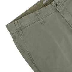 Close-up of the Green Washed Cotton Gabardine Slim Chinos by Hiltl, highlighting details like belt loops, a button, and part of the waistband.