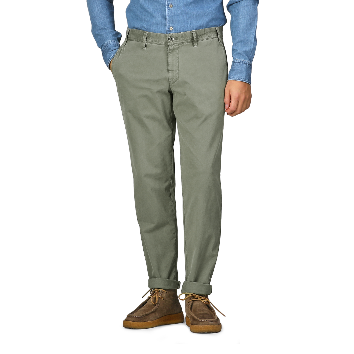 A person wearing a blue shirt, Green Washed Cotton Gabardine Slim Chinos by Hiltl, and brown shoes stands with hands in pockets.