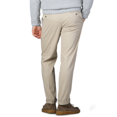 A person wearing Hiltl's Khaki Cotton Stretch Regular Fit Chinos paired with brown shoes is shown from the back. The trousers are complemented by a light gray sweater.