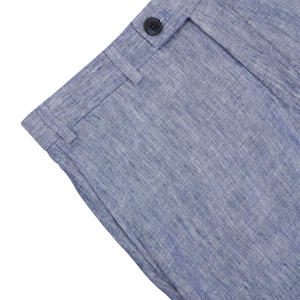 Close-up of a Hiltl Light Blue Washed Linen Regular Fit Chinos with a detailed view of the button and stitch work on a gray background.