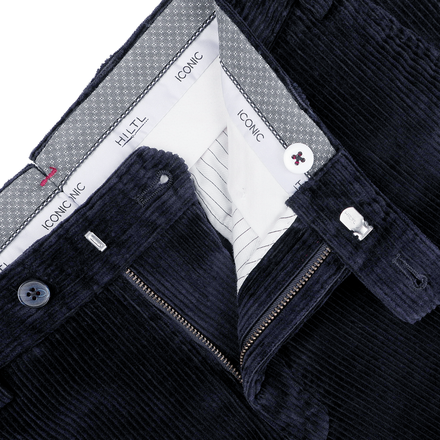 Close-up of navy blue cotton corduroy chinos with visible zipper and button fastenings, showcasing the inner waistband adorned with Hiltl's "Iconic" label patterns. These regular fit chinos provide a classic touch to any ensemble.