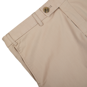 Close-up of Hiltl sand beige cotton nylon slim chinos with a button closure.