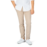 A person standing in a white shirt, Hiltl sand beige cotton nylon slim chinos, and white shoes against a gray background.