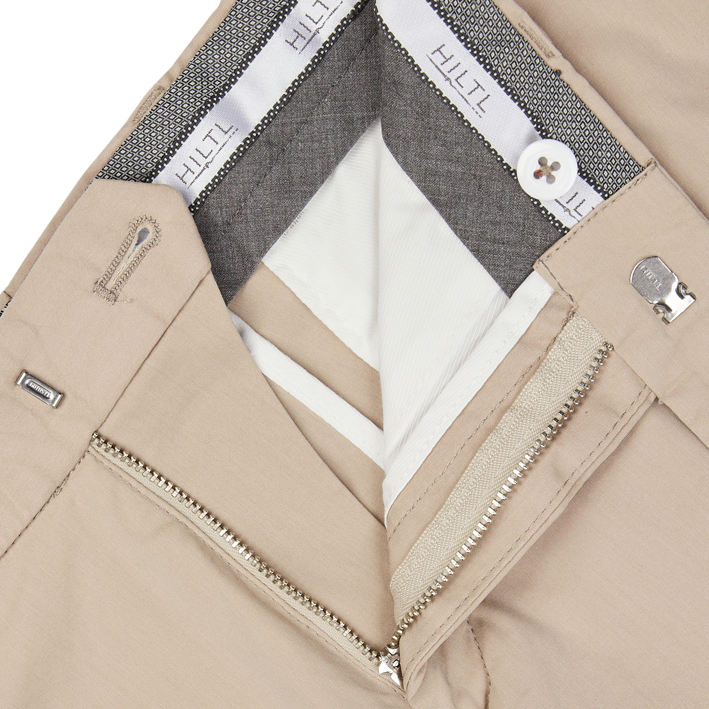 Close-up of a Hiltl sand beige jacket with silver zipper detail, a gray inner lining, and a white shirt underneath, made from a cotton-nylon blend.
