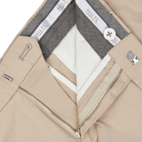 Close-up of a Hiltl sand beige jacket with silver zipper detail, a gray inner lining, and a white shirt underneath, made from a cotton-nylon blend.