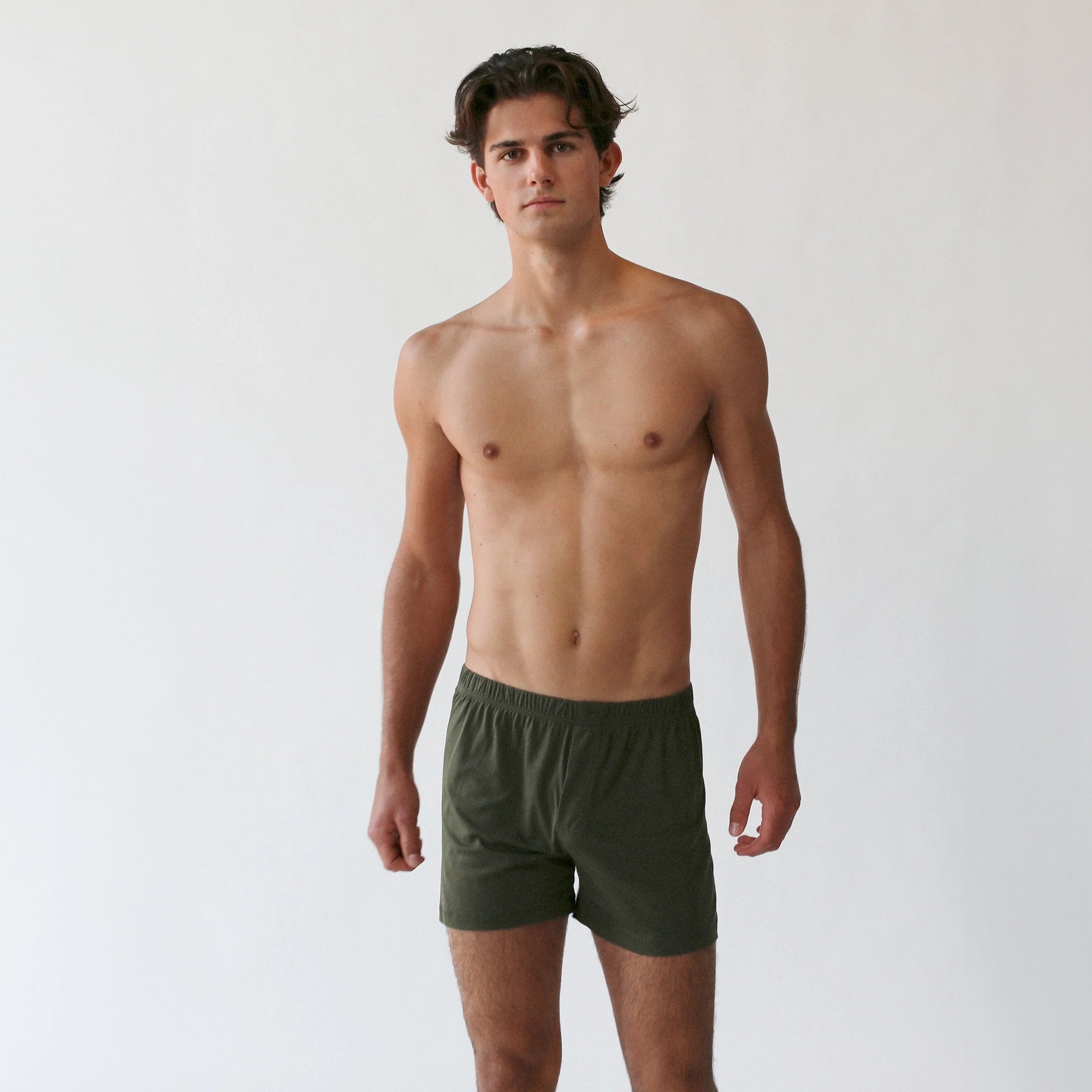 A person is standing against a plain background wearing The White Briefs' Henner Cotton Lyocell Boxer Shorts, made from a comfortable blend of lyocell and cotton.