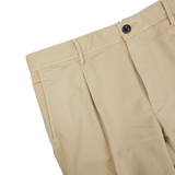 A close-up of a beige Incotex cotton stretch pleated chinos.