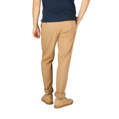 A person is shown from the back wearing a navy blue shirt, Incotex Beige Cotton Stretch Regular Chinos, and beige shoes against a plain background.