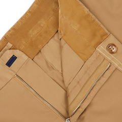 Close-up view of the inside details of Incotex Beige Cotton Stretch Regular Chinos, showcasing the zipper, button, and waistband. These khaki pants feature a regular fit with cotton stretch fabric for added comfort.