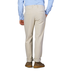 A person wearing Incotex Cream Beige Cotton Moleskin Slacks Chinos and a light blue shirt, viewed from the back.