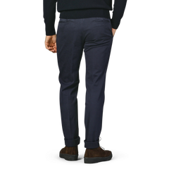 The individual is wearing a pair of Incotex Dark Blue Cotton Stretch Model 30 Chinos along with brown shoes, standing with their back to the camera.