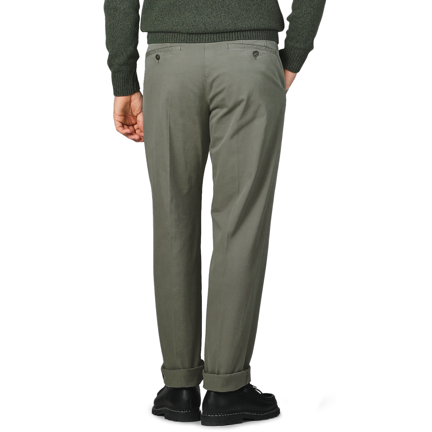 A person wearing Dark Green Cotton Stretch Model 8 Chinos by Incotex and a dark sweater stands with their back turned, hands in pockets, and is wearing black shoes.