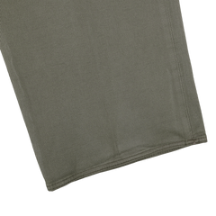 Close-up of the hem of a dark green cotton stretch pant leg by Incotex, displayed on a light gray background, highlighting the texture characteristic of Model 8 chinos.