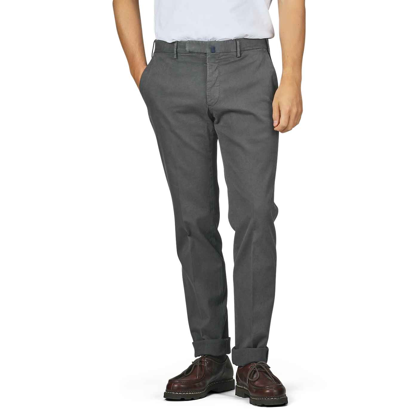 A person wearing Incotex Dark Grey Cotton Stretch Model 30 Chinos, alongside a white shirt and brown shoes, stands with hands in pockets against a plain background.