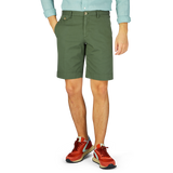 A person standing wearing Grass Green Cotton Royal Batavia Shorts by Incotex and sporty sneakers.