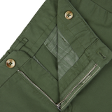 Close-up of a grass green jacket with zipper and button fastenings, paired with high-comfort Incotex shorts.