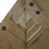 Close-up of a beige Incotex Grass Green Cotton Stretch Pleated Chinos pant with a zipper, button closure, and detailed stitching.