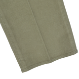 Close-up view of the hem of a pair of Green Cotton Corduroy High Comfort Chinos by Incotex, showcasing the vertical lines typical of the light brown, slim fit corduroy fabric.