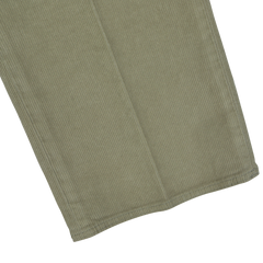 Close-up view of the hem of a pair of Green Cotton Corduroy High Comfort Chinos by Incotex, showcasing the vertical lines typical of the light brown, slim fit corduroy fabric.