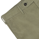 Close-up of Incotex's Green Cotton Corduroy High Comfort Chinos featuring a waistband with belt loops, a button, and a zipper fly, designed in a slim fit for added style.