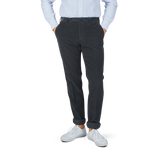 A man in Grey Micro Cotton Corduroy High Comfort Chinos by Incotex is posing.