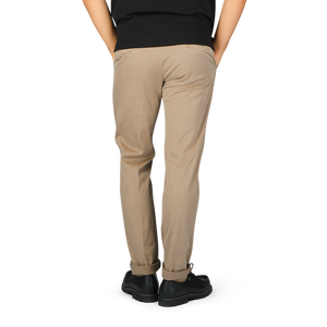 The back view of a man wearing light brown cotton stretch slacks chinos by Incotex.