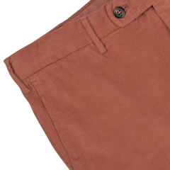 Close-up of a pair of Muted Orange Cotton Corduroy High Comfort Chinos by Incotex, showing the waistband, button, belt loops, and pocket detail.