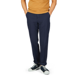 Man wearing a mustard Cotton-Linen Mix shirt and Navy Blue Chinolino Straight Fit Trousers from Incotex with white lace-up sneakers.