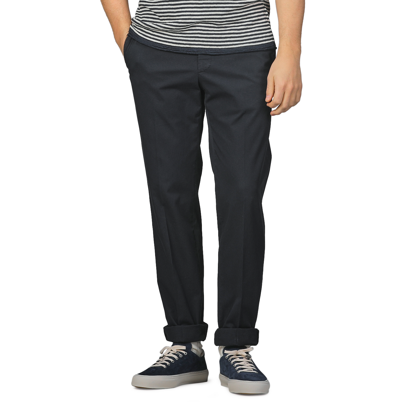 Someone wearing a striped shirt, Incotex Navy Blue Cotton Royal Batavia Regular Chinos, and dark sneakers stands with one hand in their pocket.